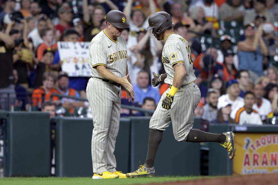 San Diego Padres third base coach Bobby Dickerson, left, and Tommy Pham, right, celebrate Pham's home run during the third inning of the team's baseball game agains the Houston Astros on Friday, May 28, 2021, in Houston. (AP Photo/Michael Wyke)