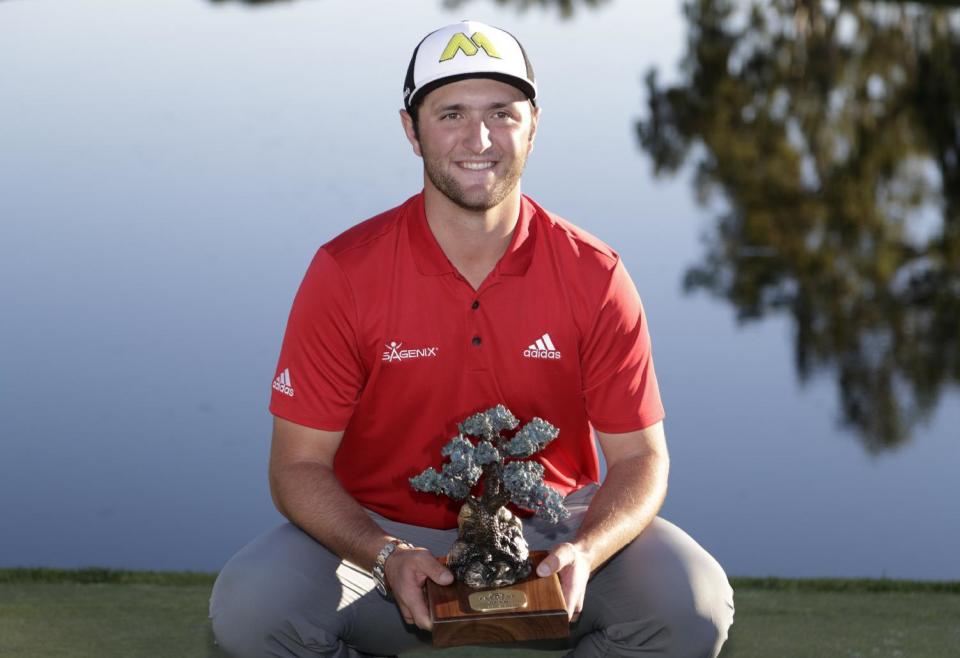 Jon Rahm, of Spain, holds the trophy after winning the Farmers Insurance Open golf tournament Sunday, Jan. 29, 2017, at Torrey Pines Golf Course in San Diego. (AP Photo/Gregory Bull)