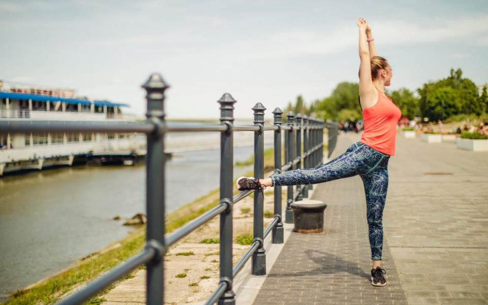 Female runner by a river - Getty