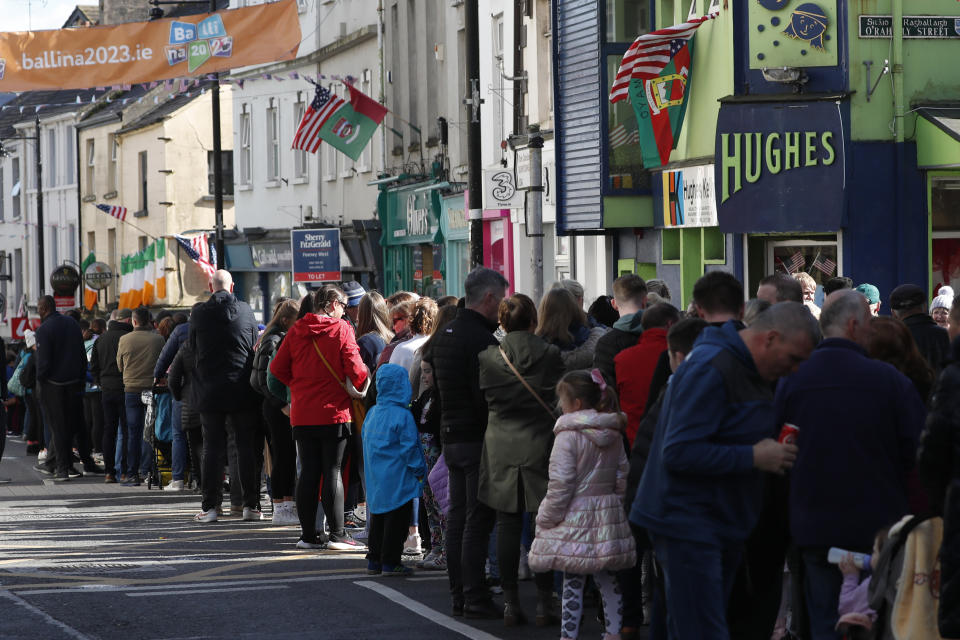 People queue to get into the staging area ahead of the visit by President Joe Biden to St Muredach's Cathedral, in Ballina, Ireland, Friday, April 14, 2023. The President will give a speech later Friday outside the cathedral. (AP Photo/Peter Morrison)