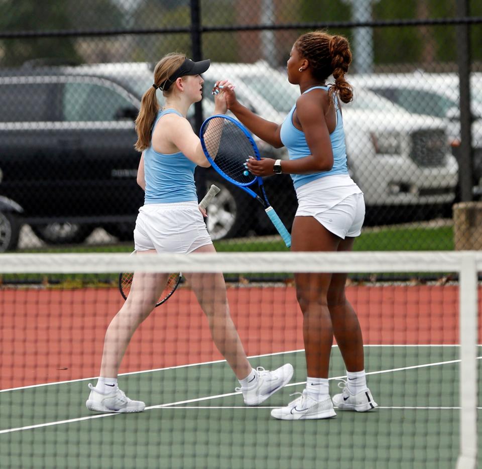 Saint Joseph freshman Libby Yergler, left, and senior Dani Graham give each other a high-five during their No. 1 doubles girls tennis match against Penn Thursday, April 18, 2024, at Penn High School in Mishawaka.