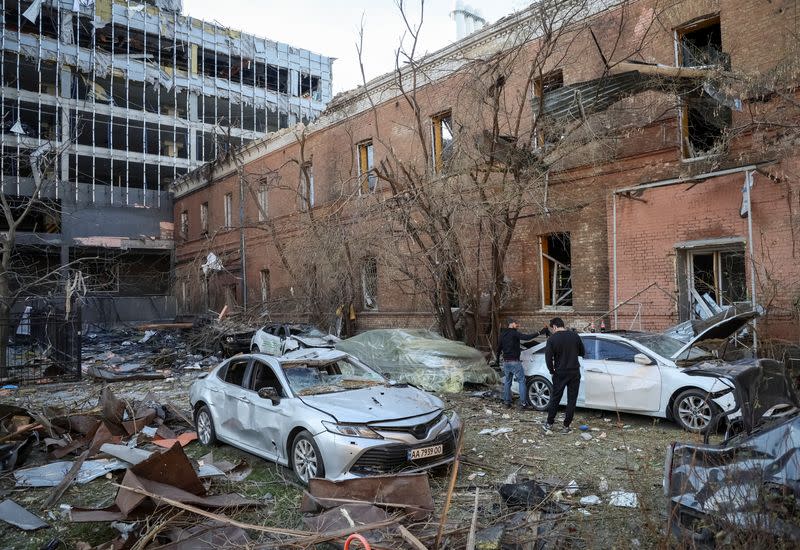 Local residents check their car, destroyed by the previous day's Russian military strike, as Russia's attack on Ukraine continues, in central Kyiv