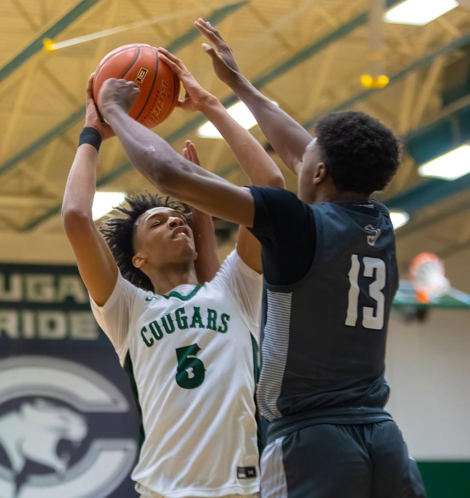 Connally forward Mekhai Bryant shoots over Hendrickson guard Amir Thompson during the second period of the Cougars' 58-50 win Friday night, which gave the Cougars their first district championship since 2006.