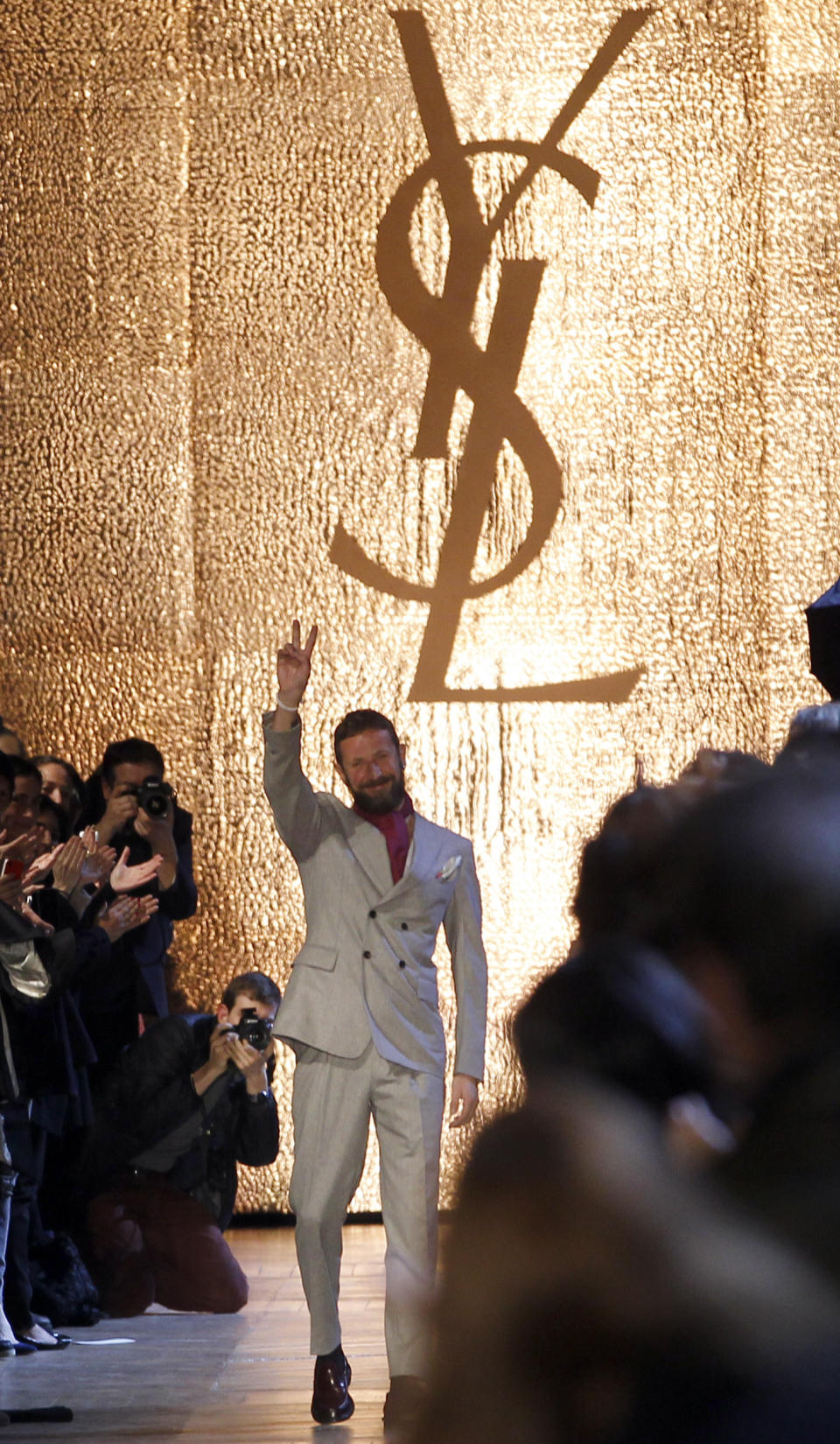 Italian designer Stefano Pilati waves after the presentation of his collection for Yves saint Laurent as part of the Fall-Winter, ready-to-wear 2013 fashion collection, during Paris Fashion week, Monday, March 5, 2012. (AP Photo/Christophe Ena)