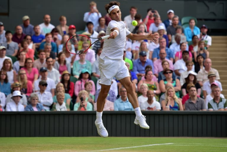 Roger Federer returns to Roberto Bautista Agut during their Wimbledon men's singles fourth round match at The All England Tennis Club in Wimbledon on July 6, 2015