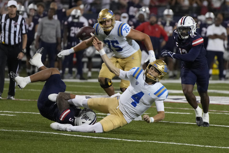 Arizona linebacker Jacob Manu (5) sacks UCLA quarterback Ethan Garbers (4) during the second half of an NCAA college football game Saturday, Nov. 4, 2023, in Tucson, Ariz. (AP Photo/Rick Scuteri)