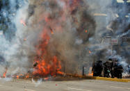 <p>Flames erupt as clashes break out near security forces members (R) while the Constituent Assembly election is being carried out in Caracas, Venezuela, July 30, 2017. (Carlos Garcia Rawlins/Reuters) </p>