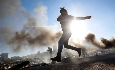 A Palestinian hurls stones during clashes with Israeli troops near the Jewish settlement of Beit El, near Ramallah, in the Israeli-occupied West Bank December 13, 2018. REUTERS/Mohamad Torokman