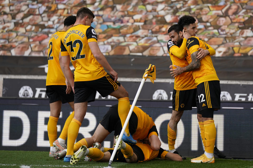 Wolverhampton Wanderers players celebrate after Morgan Gibbs-White scored his side's second goal during the English Premier League soccer match between Wolverhampton Wanderers and Brighton & Hove Albion at the Molineux Stadium in Wolverhampton, England, Sunday, May 9, 2021. (Tim Keeton/Pool via AP)