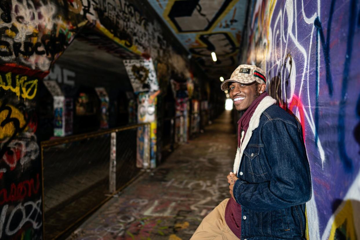 Man posing in graffiti art tunnel