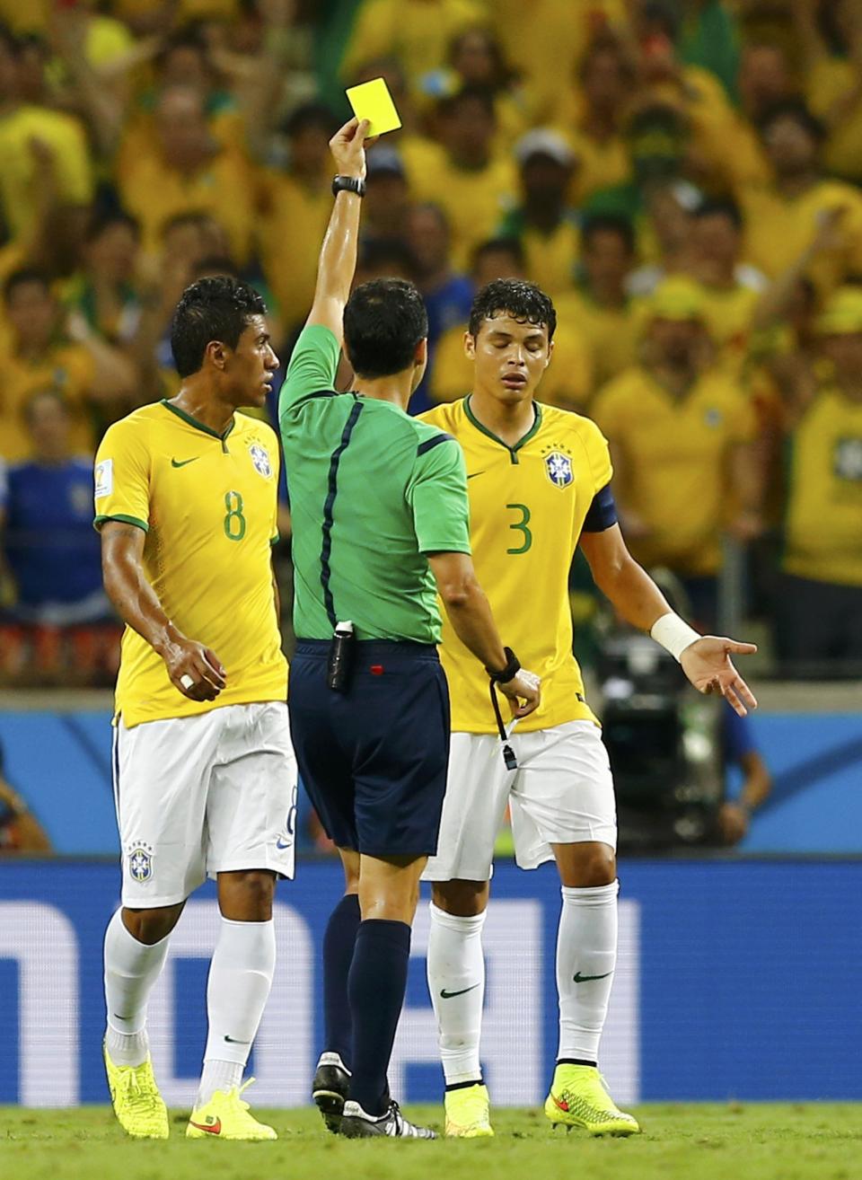 Referee Carlos Velasco Carballo of Spain shows Brazil's Thiago Silva the yellow card during the 2014 World Cup quarter-finals between Brazil and Colombia at the Castelao arena in Fortaleza July 4, 2014. REUTERS/Marcelo Del Pozo