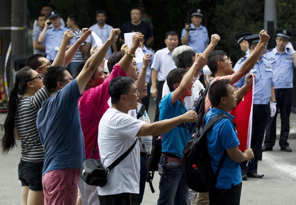 A group of Chinese protesters chant slogans in front of the Japanese Embassy during a protest against the arrests of 14 activists, in Beijing Thursday, Aug. 16, 2012. The 14 people who included Hong Kong residents and mainland Chinese, had traveled by boat from Hong Kong to a set of uninhabited islands controlled by Japan but also claimed by China and Taiwan, and were arrested on Wednesday. (AP Photo/Andy Wong)