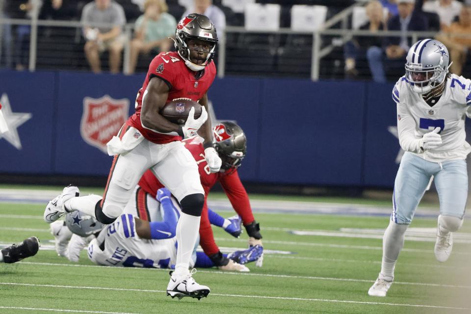 Tampa Bay Buccaneers wide receiver Chris Godwin (14) gains yardage after catching a pass as Dallas Cowboys cornerback Trevon Diggs (7) gives chase in the first half of a NFL football game in Arlington, Texas, Sunday, Sept. 11, 2022. (AP Photo/Michael Ainsworth)