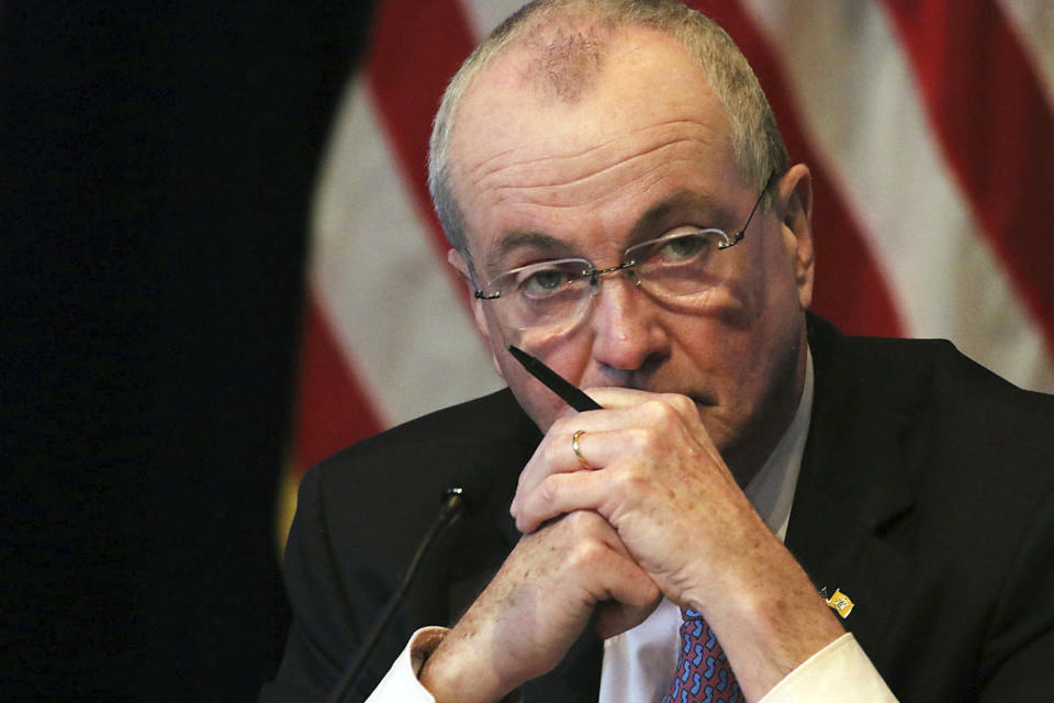 FILE - In this May 19, 2020 file photo New Jersey Gov. Phil Murphy listens during his daily coronavirus news conference at the War Memorial in Trenton, N.J. State and local government officials across the U.S. have been on edge for months about how to keep basic services running while covering rising costs related to the coronavirus outbreak as tax revenue plummeted. On Monday, Aug. 10, 2020 governors, lawmakers, mayors, teachers and others said they were going to keep pushing members of Congress to revive the talks and agree to another rescue package. (Chris Pedota/The Record via AP, Pool)