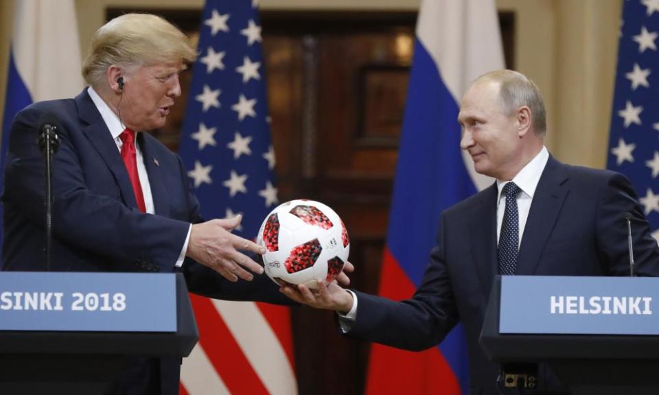 Vladimir Putin gives a World Cup football to Donald Trump on Monday.