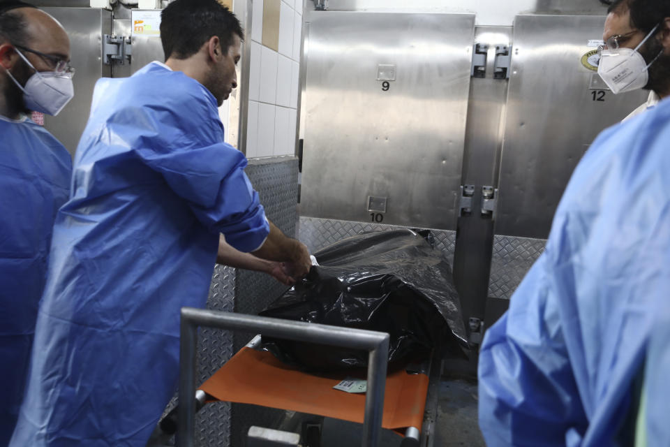 Forensic expert marks a body bag of an Israeli killed by Hamas militants in the National Center for Forensic Medicine in Tel Aviv, Monday, Oct. 16, 2023. (AP Photo/Gideon Markowicz)