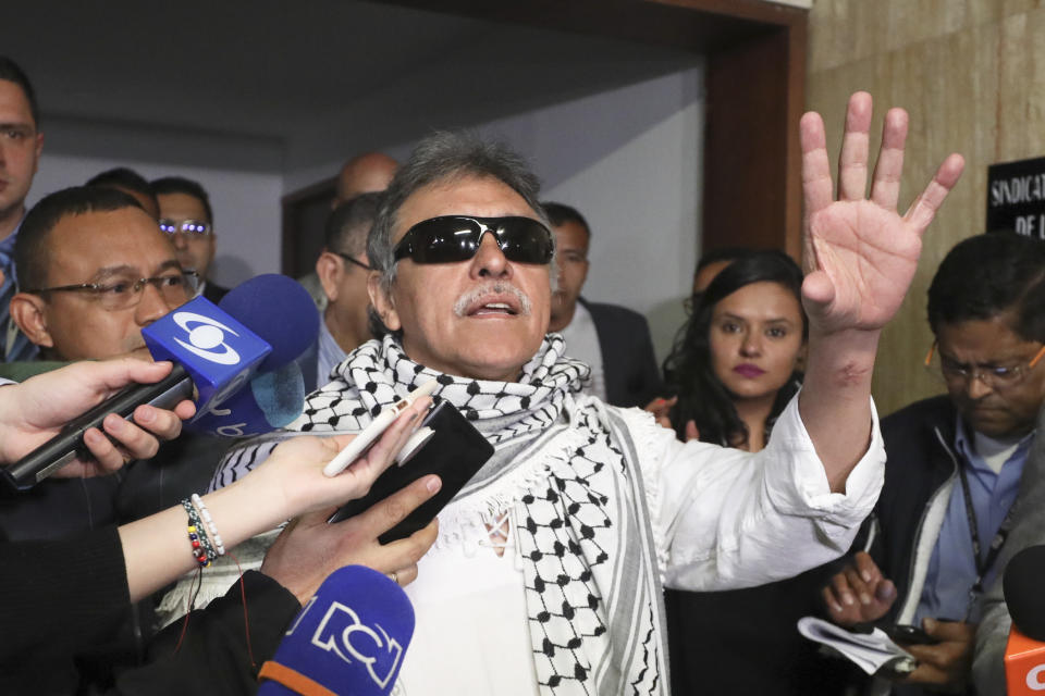 Former FARC rebel Jesus Santrich talks to journalists after swearing in to take his congressional seat in Bogota, Colombia, Tuesday, June 11, 2019. Santrich was unable to take up his seat in congress last year when he was jailed awaiting extradition to the U.S. on drug charges, but was released in a decision by the special peace tribunal. (AP Photo/Fernando Vergara)