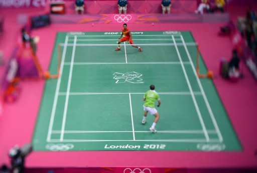This photo taken with a tilt and shift lens shows China's Lin Dan (back) competing against Ireland's Scott Evans during the men's singles badminton match at the London 2012 Olympic Games in London. Dan won 21-8, 21-14