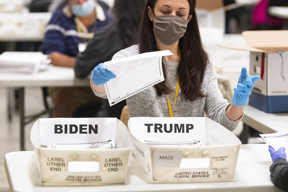 An election worker places a ballot in a counted bin during a hand recount of Presidential votes on Sunday, Nov. 15, 2020 in Marietta, Georgia.