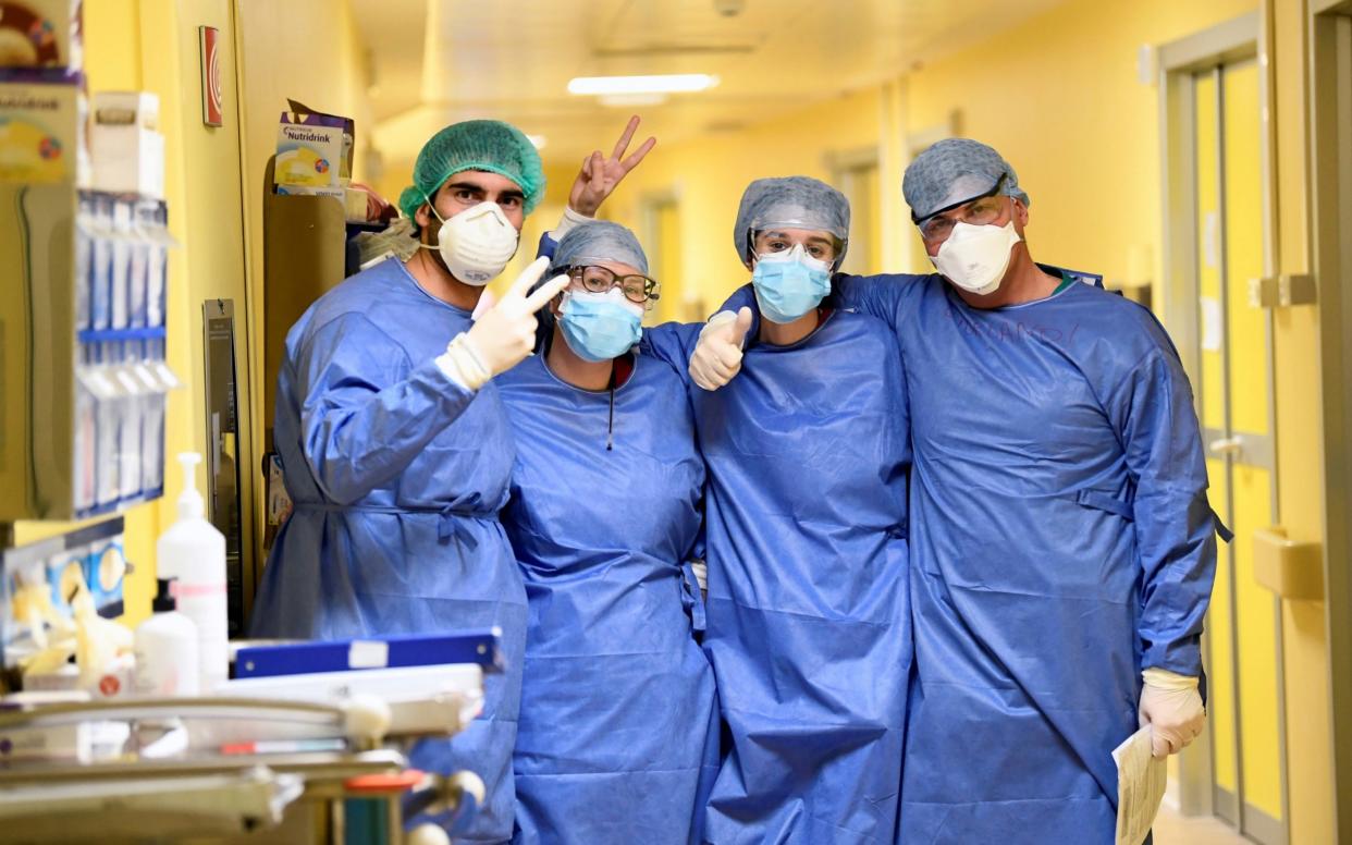 Medical staff in protective suits pose for a photo in the COVID-19 intensive care unit at the San Raffaele hospital in Milan - Reuters