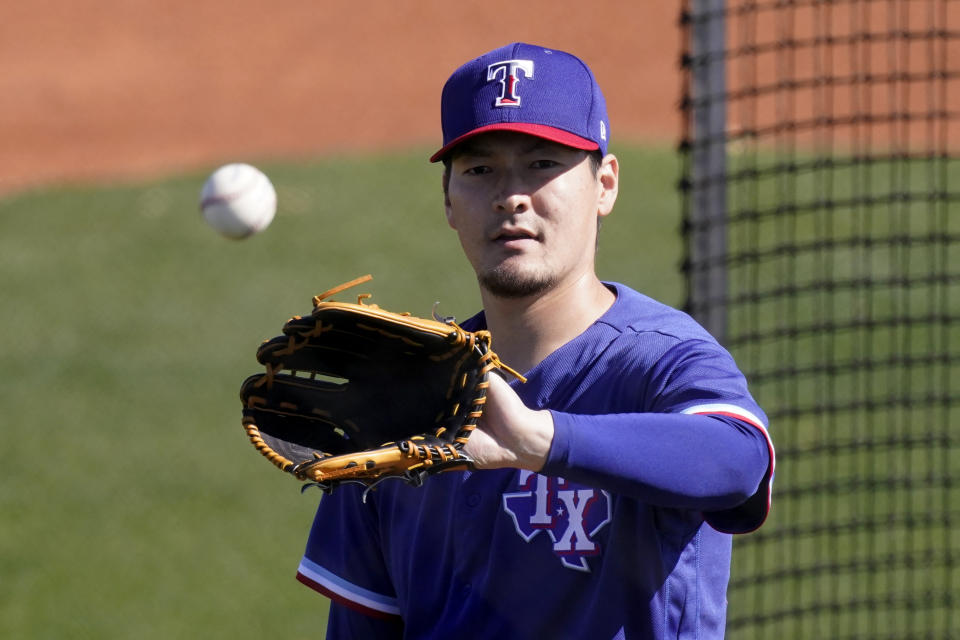 Texas Rangers pitcher Kohei Arihara catches a ball during baseball spring training Wednesday, Feb. 24, 2021, in Surprise, Ariz. (AP Photo/Charlie Riedel)