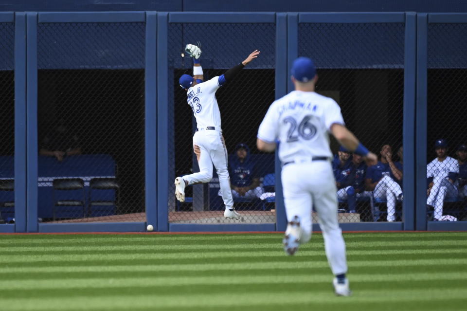 Toronto Blue Jays left fielder Lourdes Gurriel Jr., back left, is unable to make a catch on a fly ball off the bat of Detroit Tigers' Jeimer Candelario who was safe at second base with a double in the second inning of a baseball game in Toronto, Saturday, July 30, 2022. (Jon Blacker/The Canadian Press via AP)