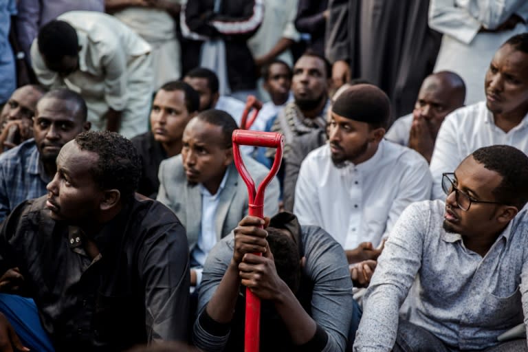 Men pray over the grave of Feisal Ahmed, one of the 21 people killed in the jihadist attack on a Nairobi office and hotel complex