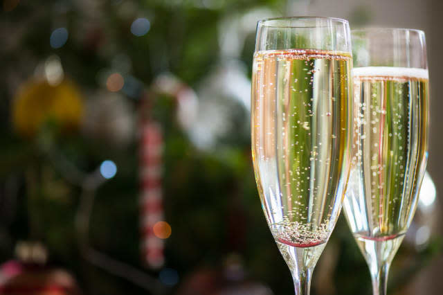 Two Champagne Flutes on Christmas Background with Xmas Tree