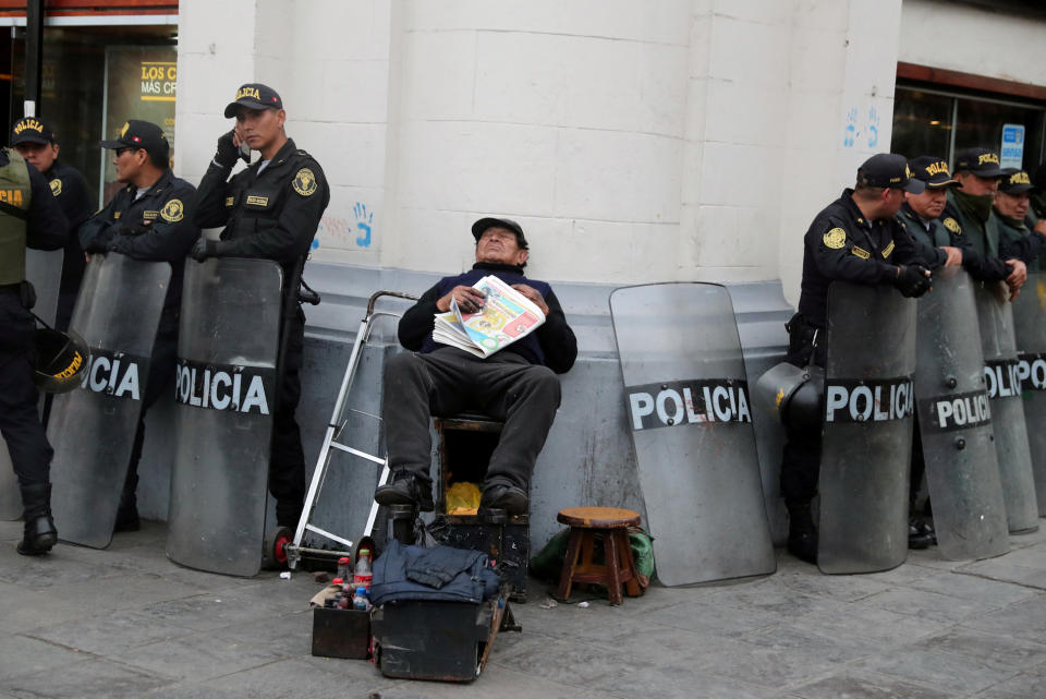 <p>Ein Schuhputzer aus Lima, Peru, gönnt sich während einer Demo gegen Korruption im öffentlichen Dienst eine kleine Auszeit. (Bild: Reuters/ Guadalupe Pardo) </p>