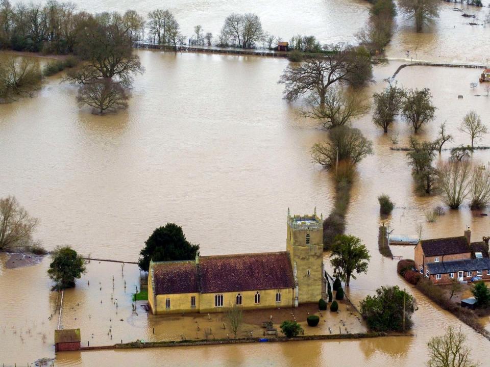 Flood water surrounds a church in Tirley, Gloucestershire, as more rain in northern England could lead to further flooding: PA