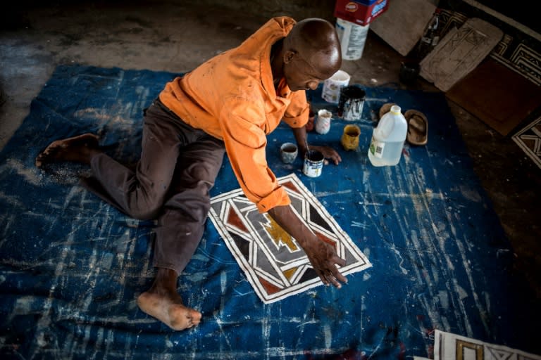 A student of Esther Mahlangu paints a design in the South African artist's home