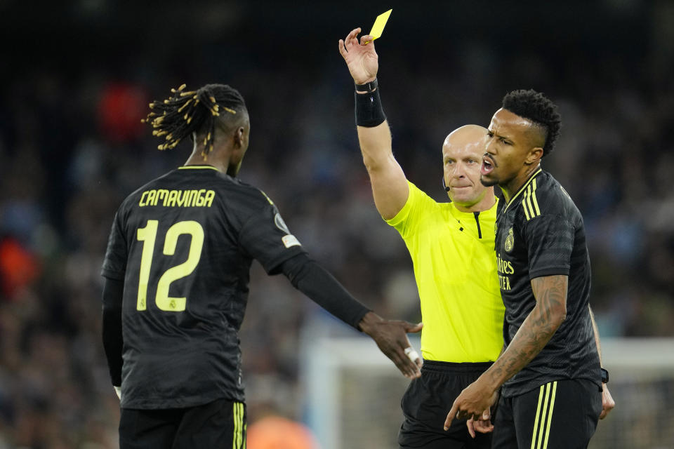 Referee Szymon Marciniak shows a yellow card to Real Madrid's Eduardo Camavinga during the Champions League semifinal second leg soccer match between Manchester City and Real Madrid at Etihad stadium in Manchester, England, Wednesday, May 17, 2023. (AP Photo/Jon Super)