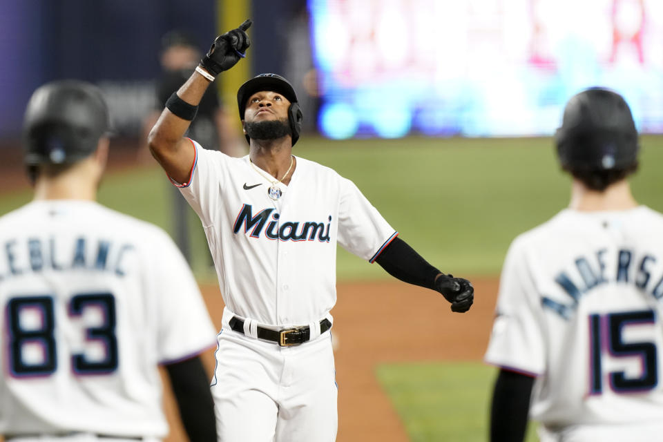 Miami Marlins' Bryan De La Cruz, center, crosses the plate to score after hitting a grand slam during the third inning of a baseball game against the Chicago Cubs, Monday, Sept. 19, 2022, in Miami. (AP Photo/Lynne Sladky)