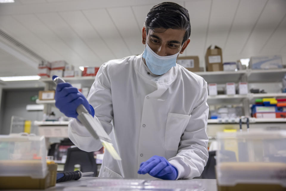 Britian's Chancellor of the Exchequer Rishi Sunak gestures during a visit to Imperial Clinic Research Facility at Hammersmith Hospital, where he met staff and was instructed on research techniques, to mark the announcement of his Spending Review, in London, Wednesday, Nov. 25, 2020. (Jack Hill/Pool Photo via AP)