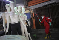 A fireman sprays disinfectant at mannequins as a precaution against coronavirus outbreak, at Tanah Abang textile market in Jakarta, Indonesia, Thursday, June 4, 2020. Authorities in Indonesia's capital will ease a partial lockdown as the world's fourth most populous nation braces to gradually reopen its economy. (AP Photo/Dita Alangkara)