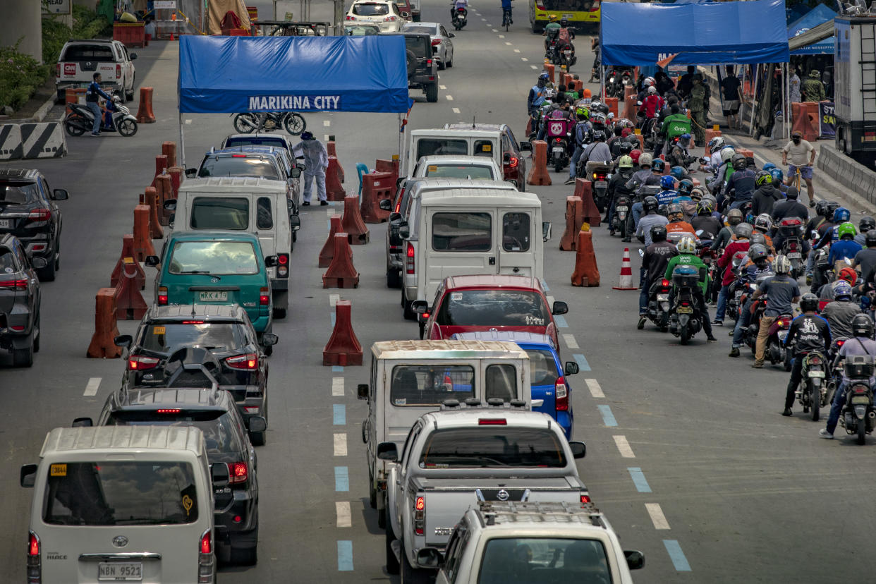 Motorists queue at a quarantine checkpoint, after the government relaxed lockdown measures and allowed work to resume in more industries on May 18, 2020 in Marikina, Metro Manila, Philippines. (Photo by Ezra Acayan/Getty Images)