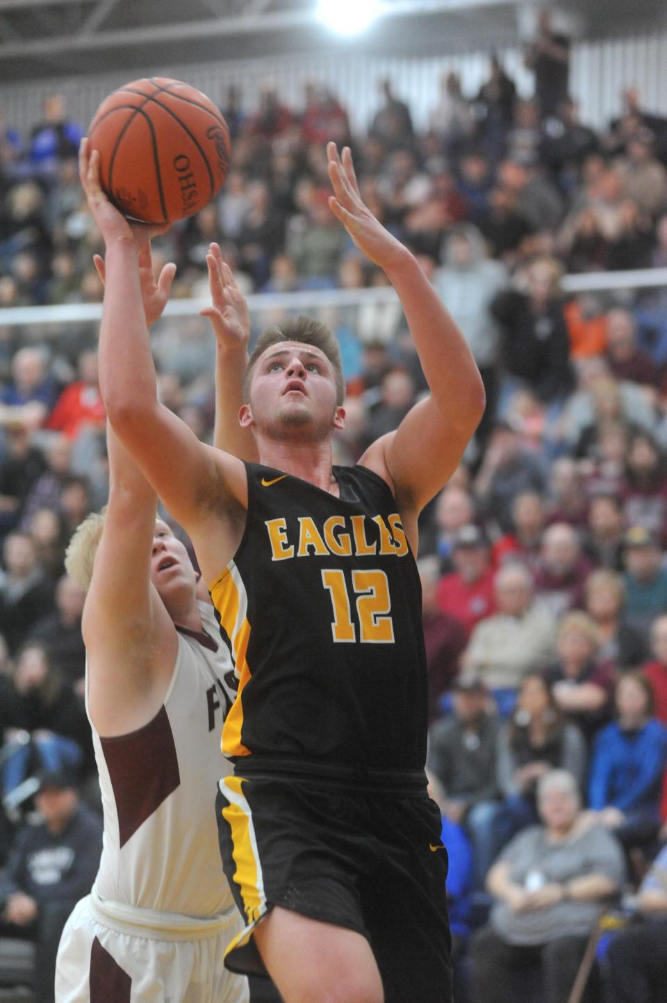 Colonel Crawford's Gavin Feichtner slips past Willard's Austin Adelman for a basket.