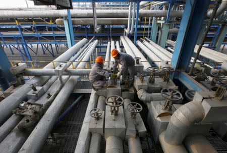 Employees close a valve of a pipe at a PetroChina refinery in Lanzhou, Gansu province January 7, 2011. REUTERS/Stringer/File Photo