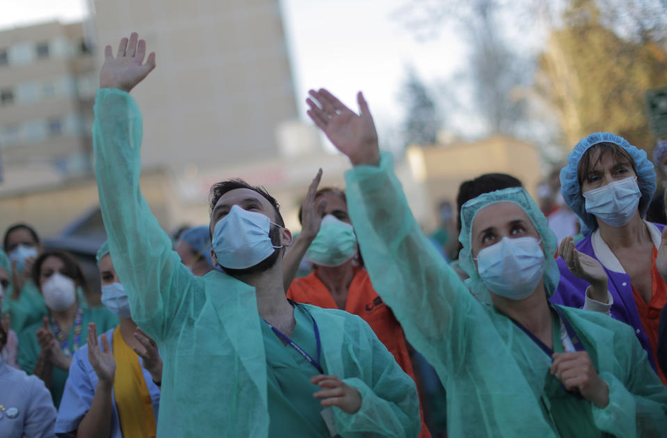 Health workers applaud as people react from their houses in support of the medical staff that are working on the COVID-19 virus outbreak at the Gregorio Maranon hospital in Madrid, Spain, Wednesday, April 1, 2020. The new coronavirus causes mild or moderate symptoms for most people, but for some, especially older adults and people with existing health problems, it can cause more severe illness or death. (AP Photo/Manu Fernandez)