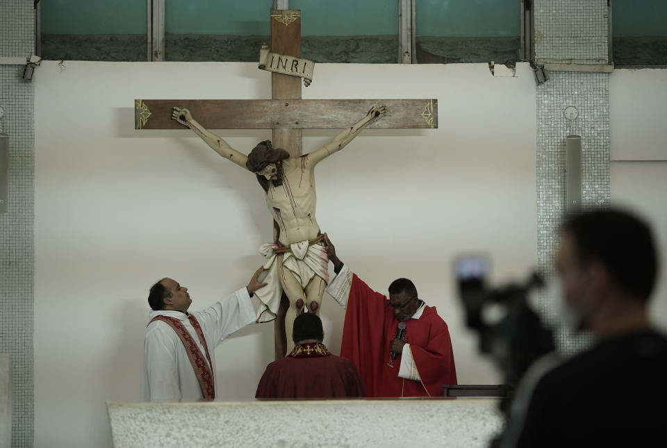 Priests celebrate the Passion of Christ Mass broadcast via a live video stream inside the empty Sao Jose da Lagoa Catholic church in Rio de Janeiro, Brazil, on Good Friday, April 10, 2020. Christians are marking Good Friday in a world locked down by the COVID-19 pandemic, unable to attend solemn church services or religious processions as in past years.(AP Photo/Silvia Izquierdo)