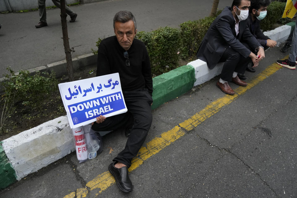 A demonstrator holds an anti-Israeli placard during a rally in front of the former U.S. Embassy in Tehran, Iran, marking 44th anniversary of the seizure of the embassy by militant Iranian students, Saturday, Nov. 4, 2023. (AP Photo/Vahid Salemi)