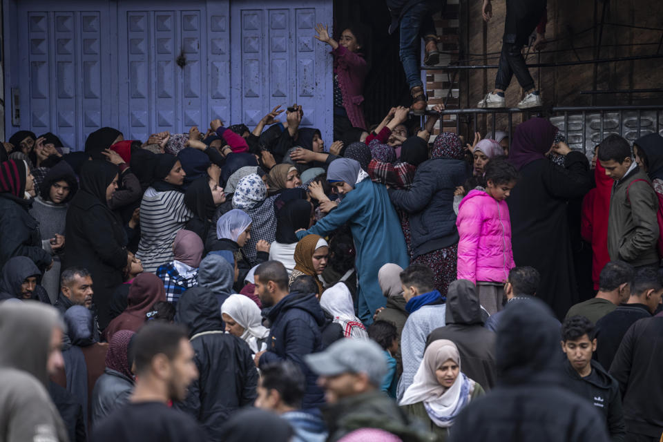 File - Palestinian crowds struggle to buy bread from a bakery in Rafah, Gaza Strip, Sunday, Feb. 18, 2024. (AP Photo/Fatima Shbair, File)