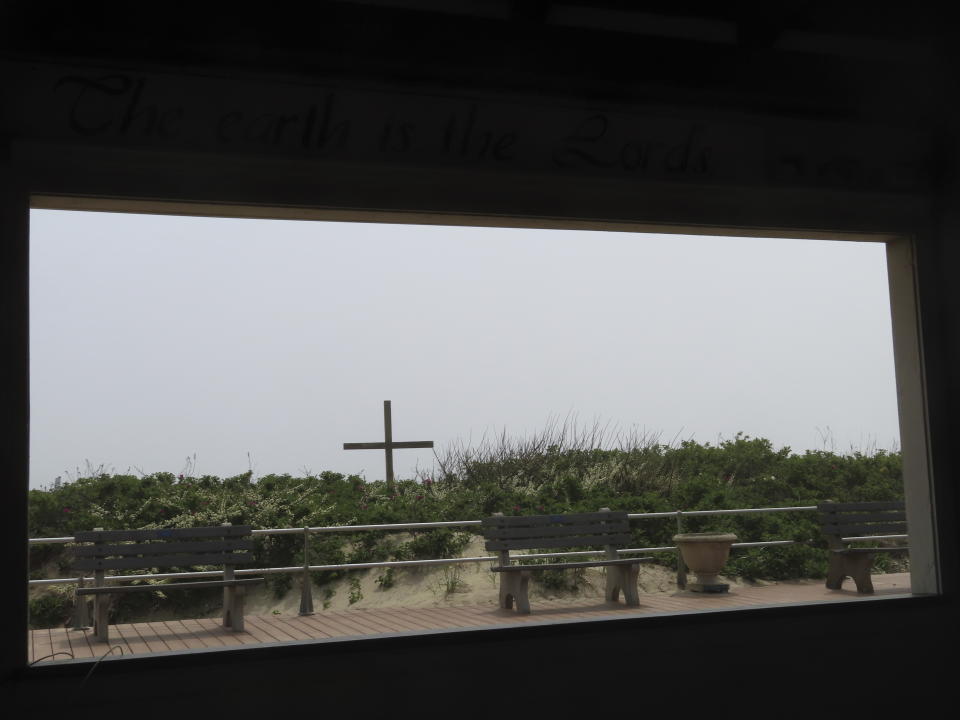 A cross on the beach in Ocean Grove, N.J. is visible on May 2, 2024 from inside a boardwalk pavilion in which a Christian religious group holds Sunday morning services during the summer. The state of New Jersey says the Ocean Grove Camp Meeting Association is violating state beach access laws by keeping people off the beach until noon on Sundays. (AP Photo/Wayne Parry)