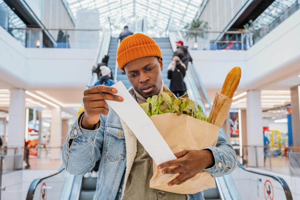 Man looking at the receipt for his groceries