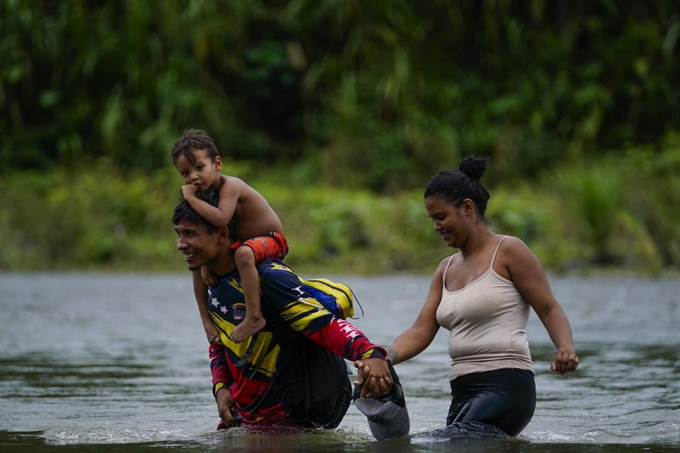 Venezuelan migrants wade across the Tuquesa river after trekking through the Darien Gap, in Bajo Chiquito, Panama, Wednesday, Oct. 4, 2023. (AP Photo/Arnulfo Franco)