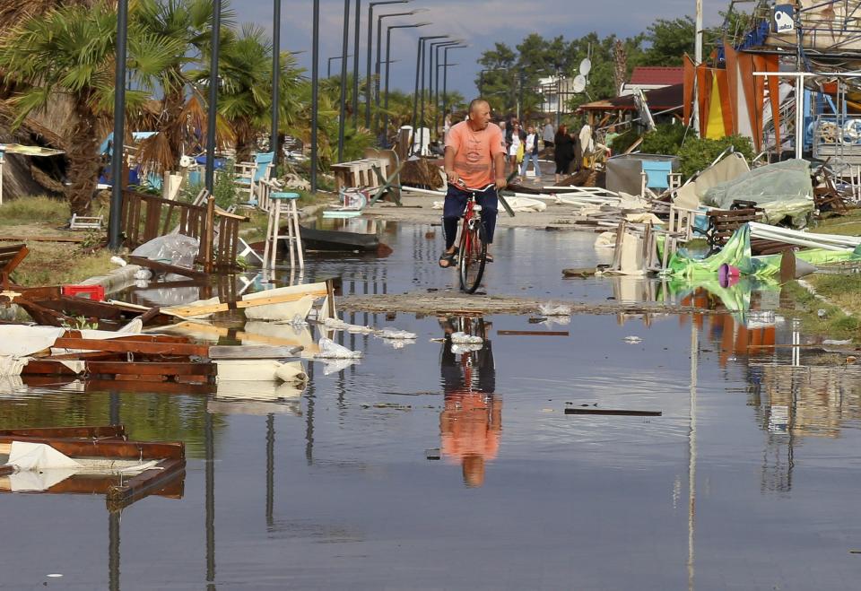 A man rides a bicycle among debris after a storm at Nea Plagia village in Halkidiki region, northern Greece, Thursday, July 11, 2019. A powerful storm hit the northern Halkidiki region late Wednesday. (Giannis Moisiadis/InTime News via AP) (Giannis Moisiadis/InTime News via AP)