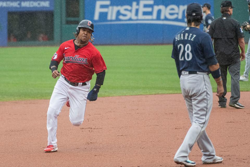 Guardians All-Star Jose Ramirez heads to third base, passing Seattle's Eugenio Suarez, on his way to scoring on a double by Josh Naylor during the first inning in Cleveland, Sunday, Sept. 4, 2022.