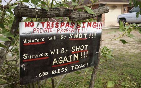 A handmade sign to deter trespassers hangs in the front yard of Fernando Rivera Jr.'s house in Brownsville, Texas September 2, 2014. REUTERS/Rick Wilking