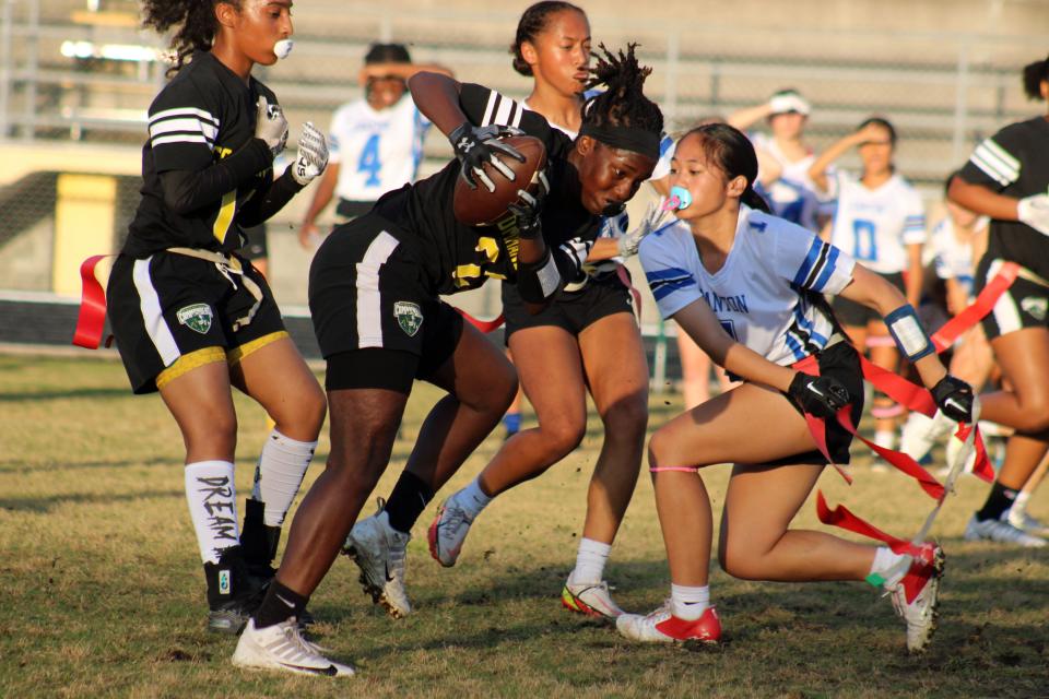 Ed White receiver Tremesha Harris (23) tries to dodge the flag pull of Stanton's Gabrielle Fajardo (1) during the Gateway Conference high school flag football championship.