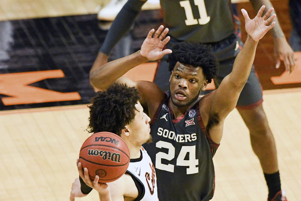 Oklahoma State guard Cade Cunningham (2) looks to pass while under pressure from Oklahoma guard Elijah Harkless (24) during an NCAA college basketball game Monday, March 1, 2021, in Stillwater, Okla. (AP Photo/Brody Schmidt)